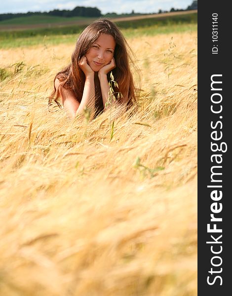 Beautiful young woman relaxing in golden field