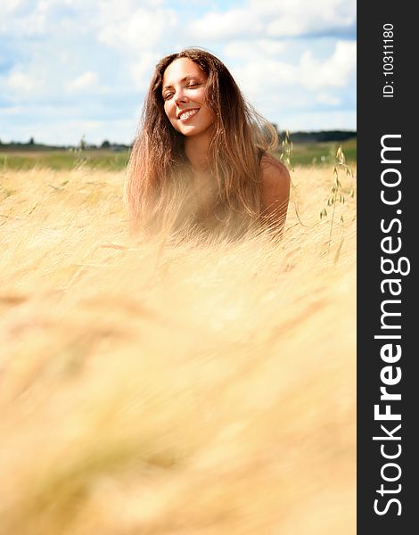 Beautiful young woman relaxing in golden field. Beautiful young woman relaxing in golden field