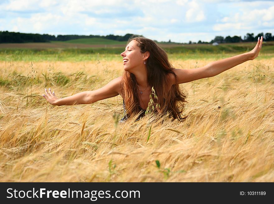 Beautiful young woman relaxing in golden field. Beautiful young woman relaxing in golden field