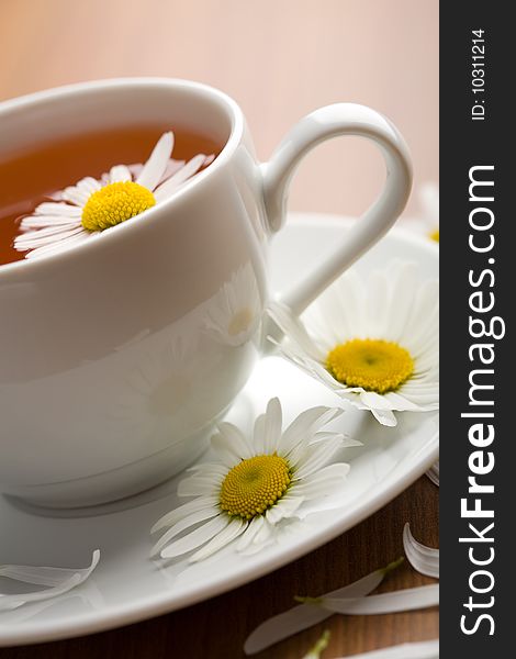 Cup of herbal tea and chamomile flowers