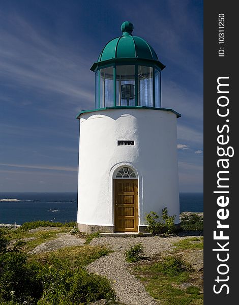 A small lighthouse on the island of North Koster with the Swedish archipelago in the background. A small lighthouse on the island of North Koster with the Swedish archipelago in the background.