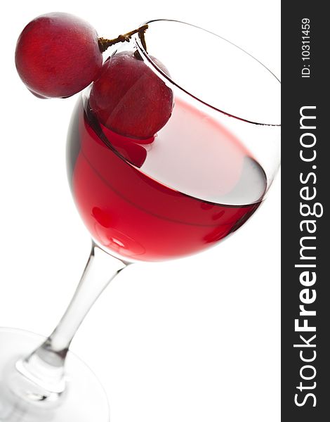 Glass of red wine and grapes isolated