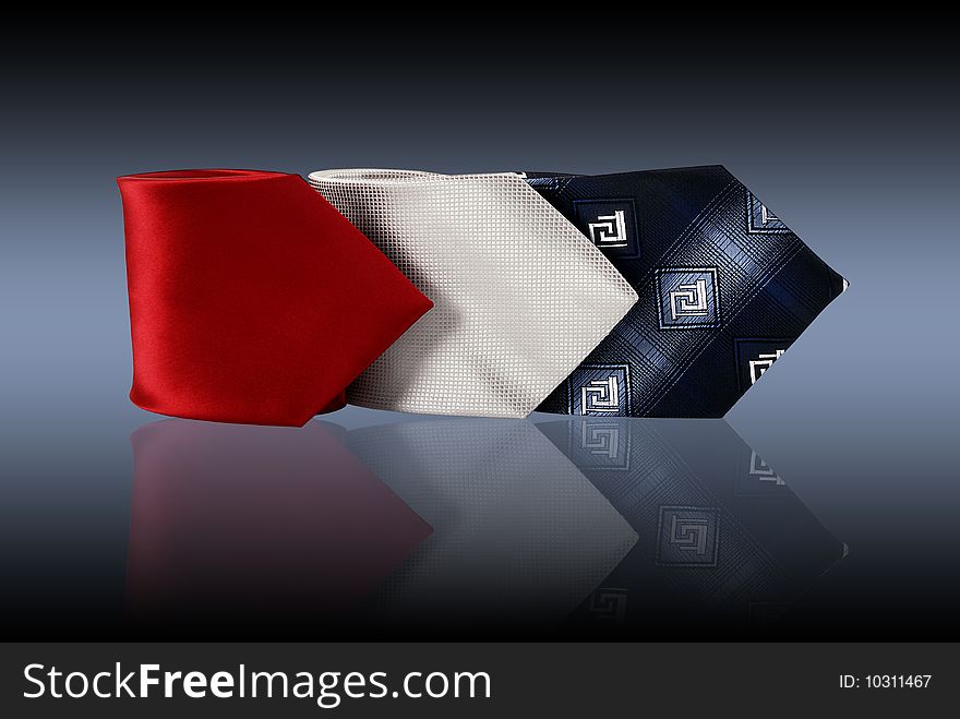 Three ties on a grey reflective background. Three ties on a grey reflective background.