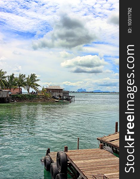 Landscape view of jetty on cloudy sunny day.