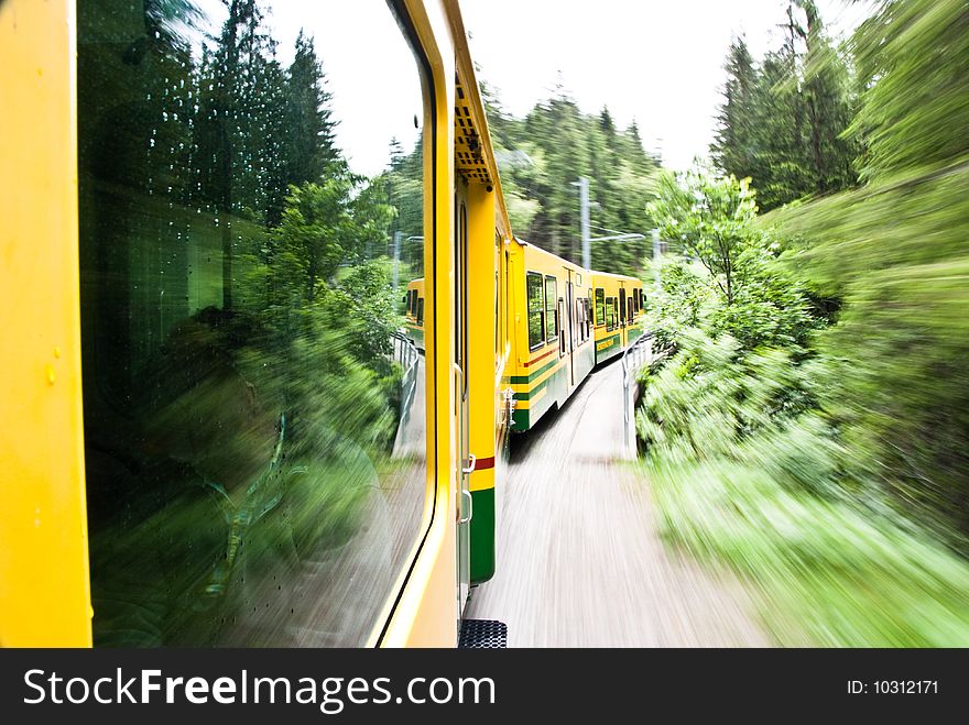Running yellow train in Switzerland natural forest. Running yellow train in Switzerland natural forest
