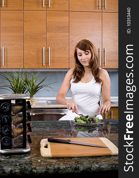 Woman eating a salad in a modern kitchen