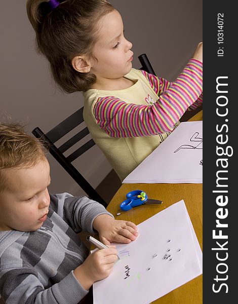 Girl and boy drawing a picture at the table. Girl and boy drawing a picture at the table