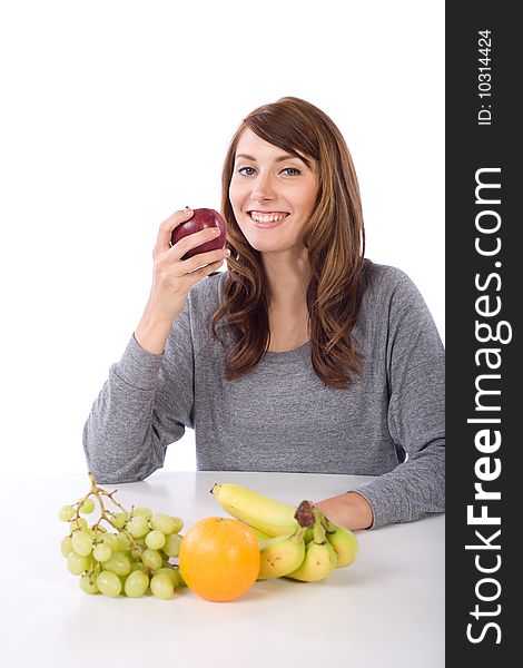 Woman eating fruit in a modern kitchen. Woman eating fruit in a modern kitchen