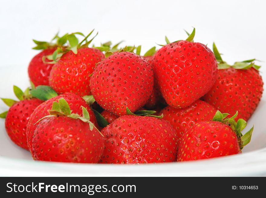 A plate of red and juicy strawberries