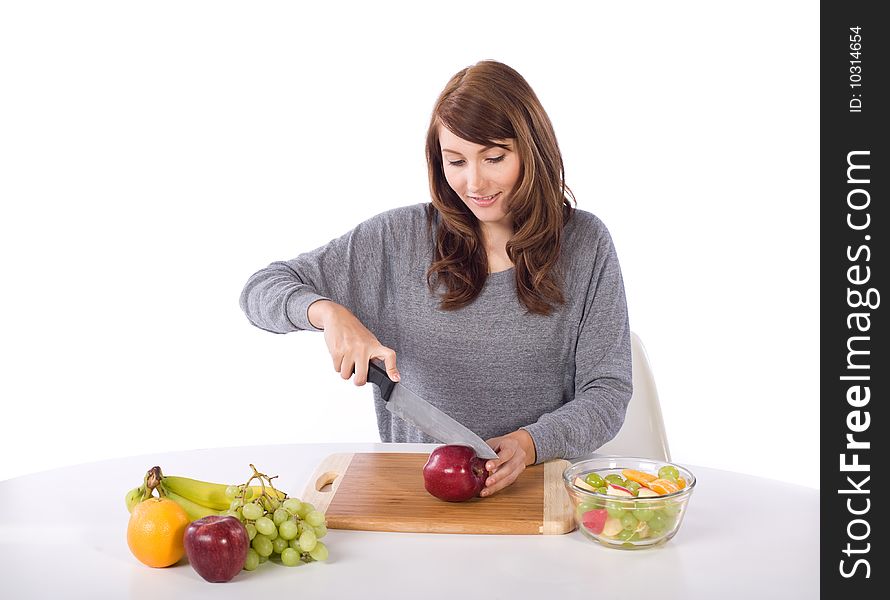 Woman cutting an apple for a fruit salad