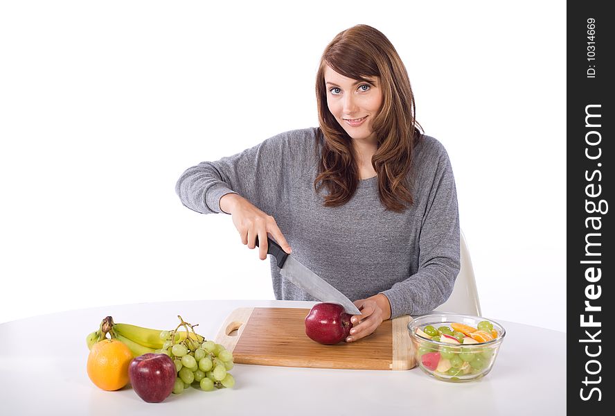 Woman cutting an apple for a fruit salad