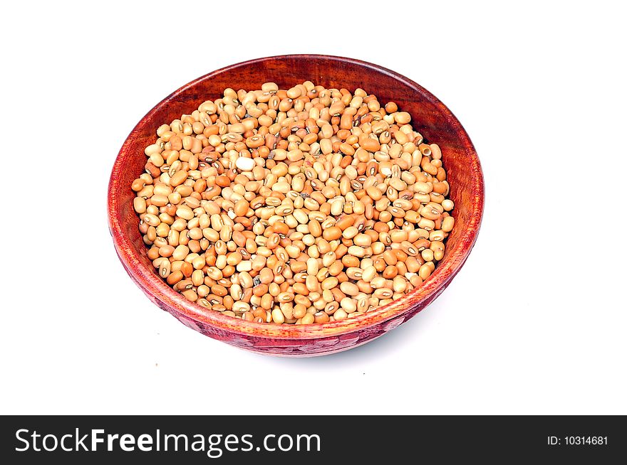 Brown lentils in wooden bowl isolated on white background.