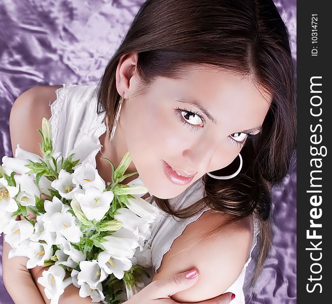 Beautiful brunette hold a bouquet white flowers