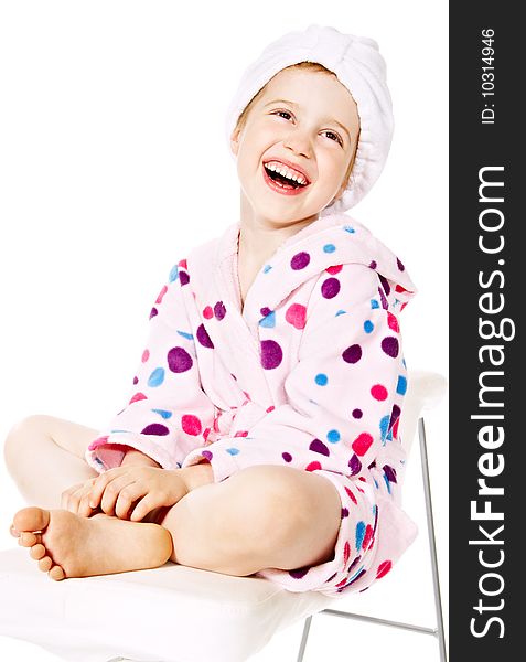 Smiling little girl in pink bathrobe after a bath