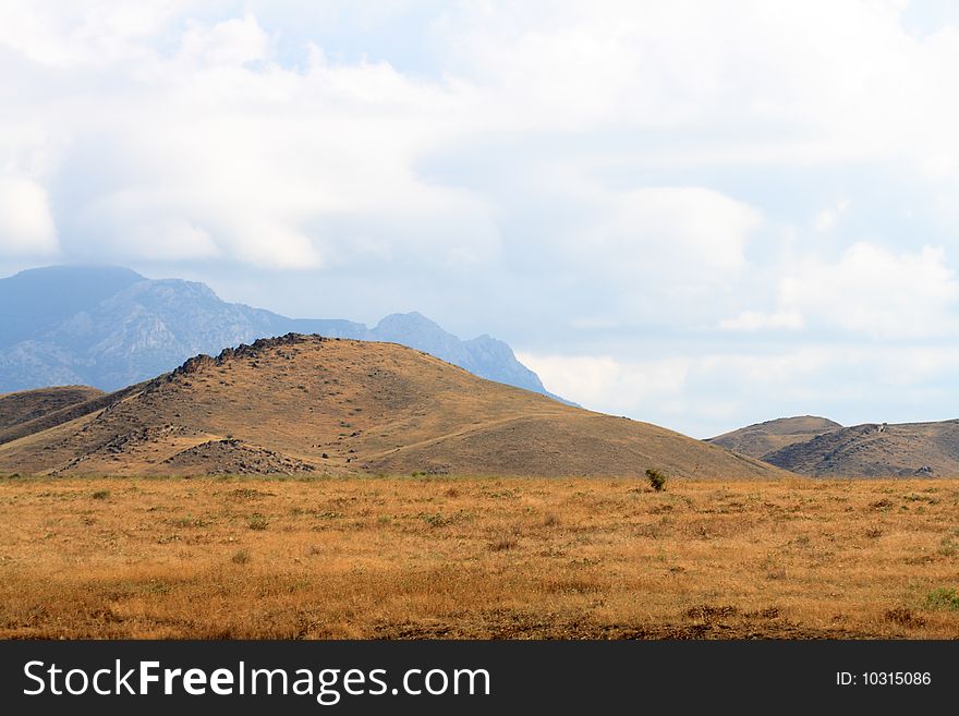 Nice Crimea summer landscape with yellow steppe and mountains. Nice Crimea summer landscape with yellow steppe and mountains