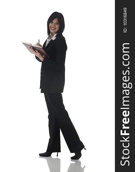 Beautiful brunette businesswoman in business suit writing in her daybook on white background. Not isolated