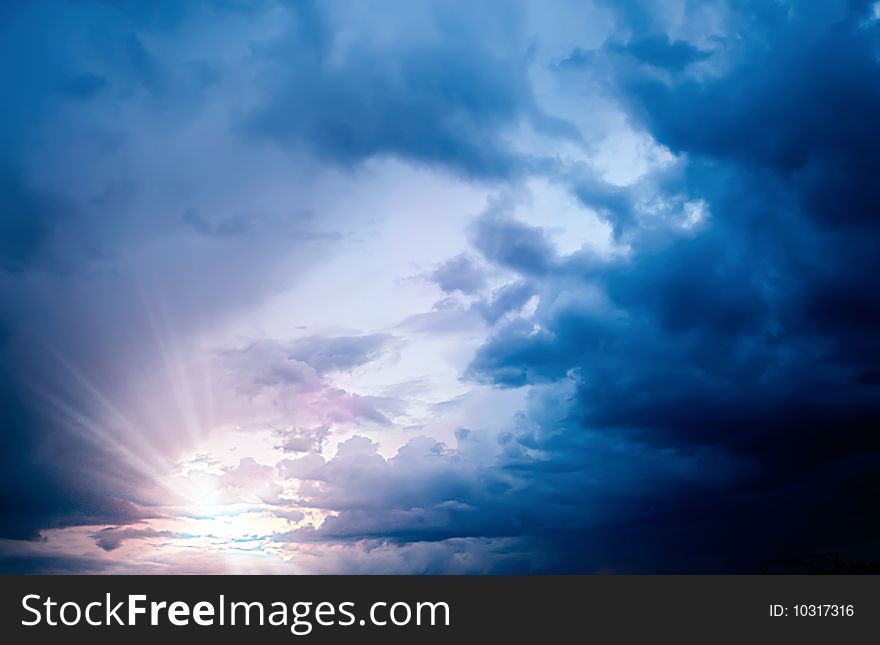 Stormy clouded sky background with sun setting