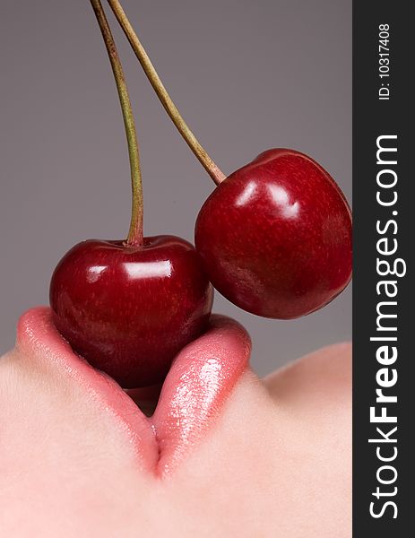 Healthy young woman eating red cherries