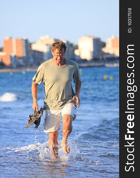 Happy young man running close to the sea