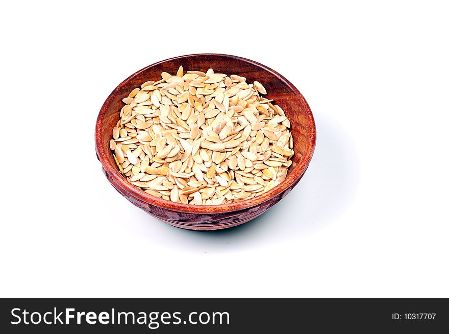 Roasted melon seeds in wooden bowl.