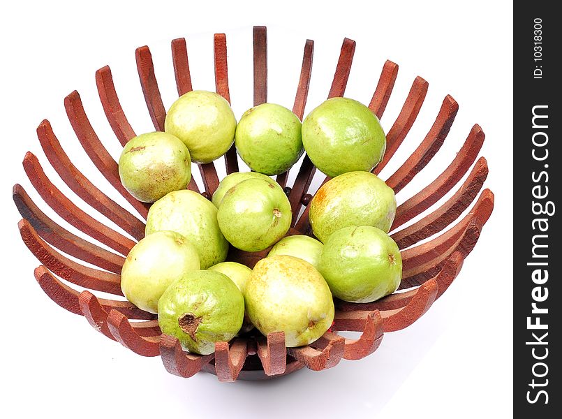 Green guavas in wooden basket.