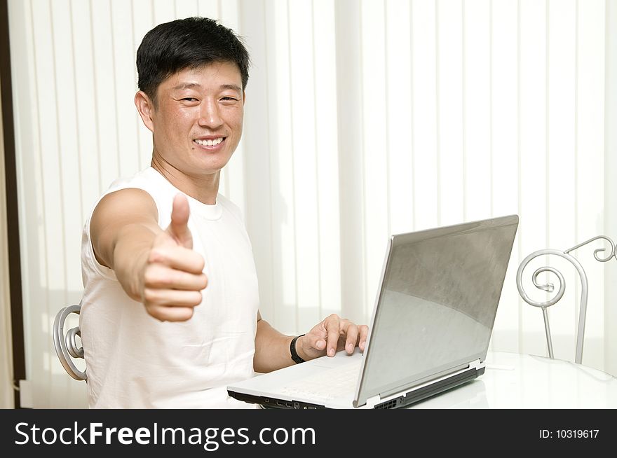 Businessman working with laptop and shows the OK sign - successful manager in the office with notebook
