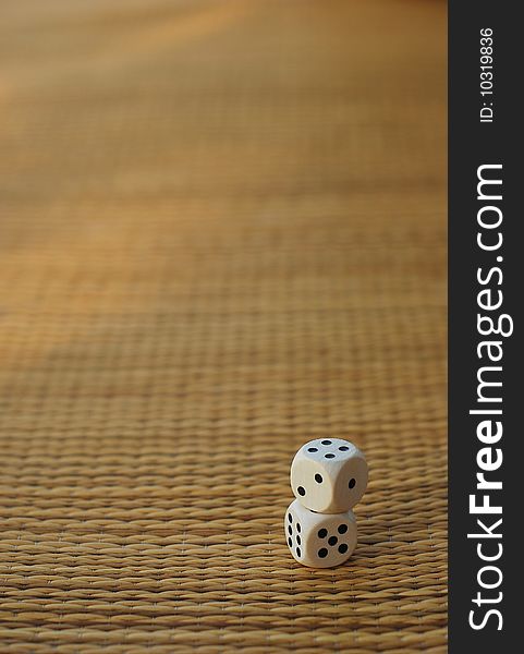 Two dices on a bamboo mat. blurry background