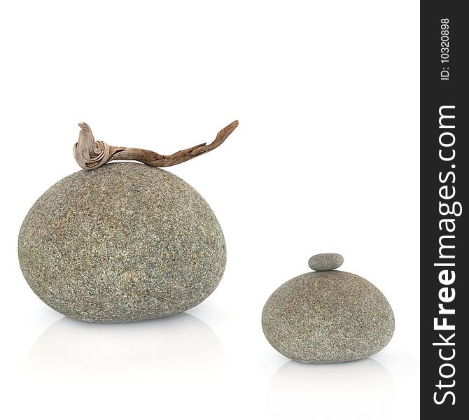 Zen abstract of two grey stones one with a piece of driftwood the other with a small stone balanced on the top, over white background. Zen abstract of two grey stones one with a piece of driftwood the other with a small stone balanced on the top, over white background.