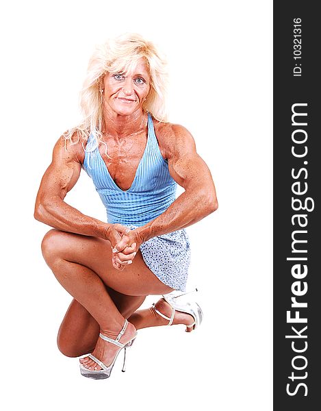 A blond muscular bodybuilding girl kneeling in the studio shooing her strong arms, in high heels, and shooing the biceps, over white background. A blond muscular bodybuilding girl kneeling in the studio shooing her strong arms, in high heels, and shooing the biceps, over white background.