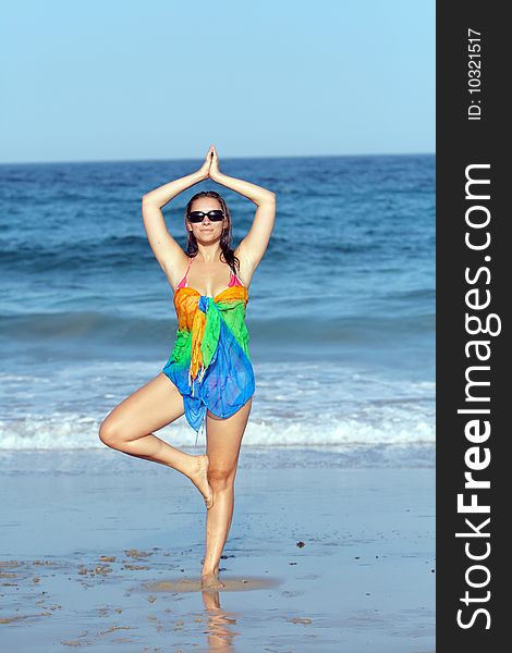 Woman doing yoga on the beach