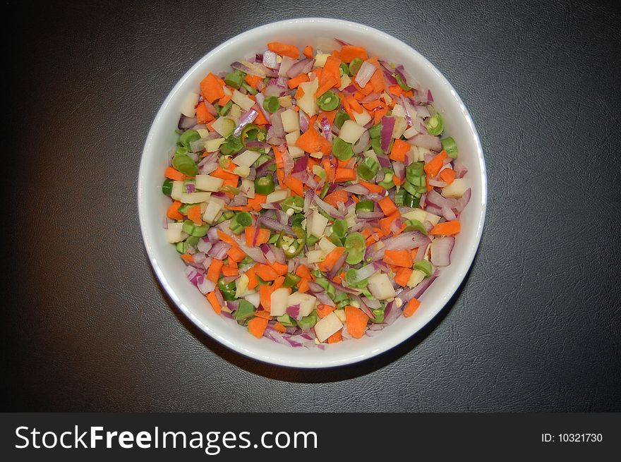 Salad containing beans,carrots,onions,chillies and potatos.