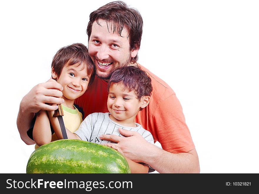 father and two kids preparing watermelon