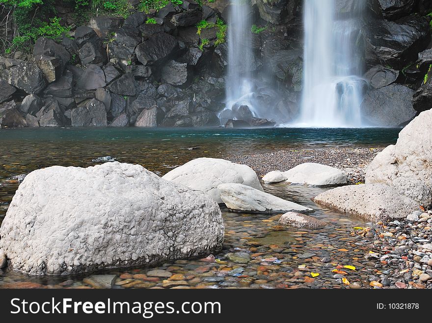 Landscape shot of majestic waterfall splashing onto rocks