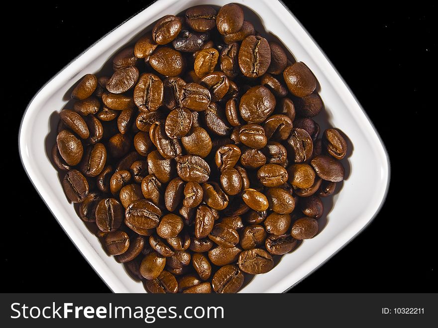 A white bowl of coffee on an isolated black background. A white bowl of coffee on an isolated black background