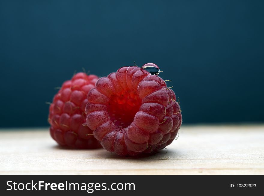 Fresh and tasty raspberries on the blue background