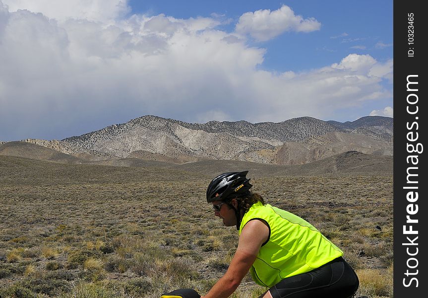 Man Cycling through Nevada Desert on Cross Country Adventure. Man Cycling through Nevada Desert on Cross Country Adventure