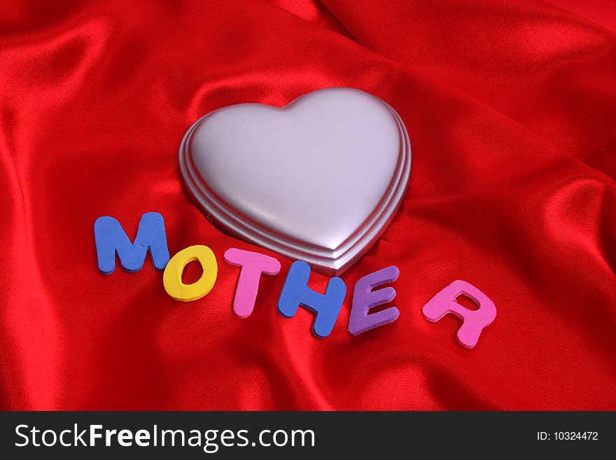 Mother and a silver heart on red satin