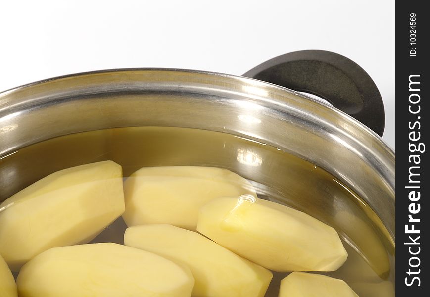 Fresh raw peeled potatoes into the steel pan. Is not isolated image