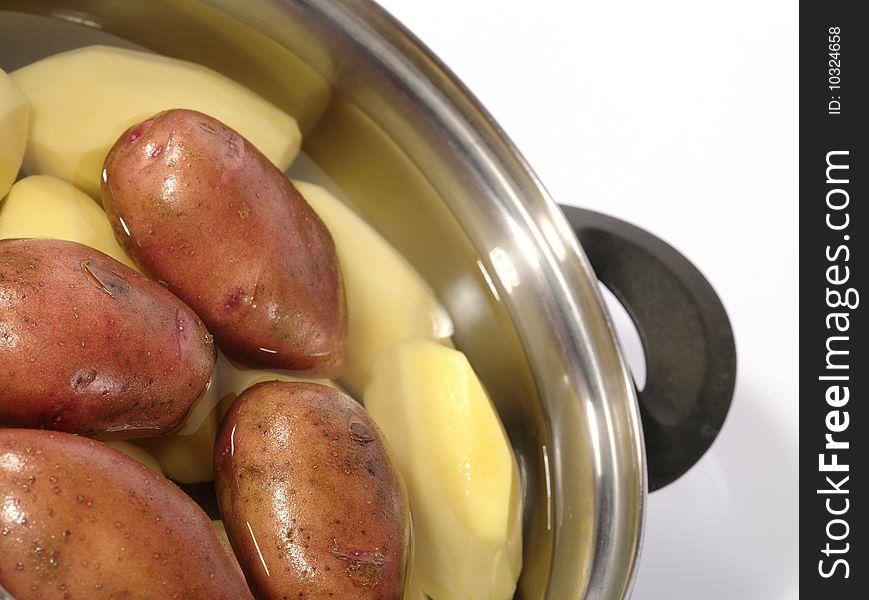 Fresh raw potatoes into the steel pan. Is not isolated image