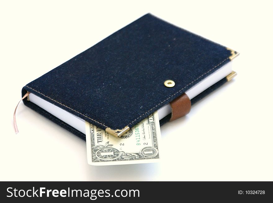 Notebook and dollar on a white background. Dollar between pages