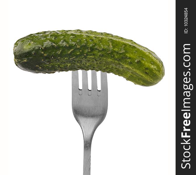 Fresh green cucumber on the fork. Vegan food concept. Isolated over white