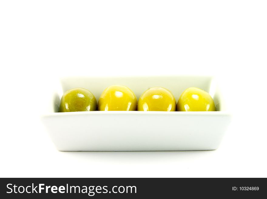 Four green olives in a small dish on a white background. Four green olives in a small dish on a white background