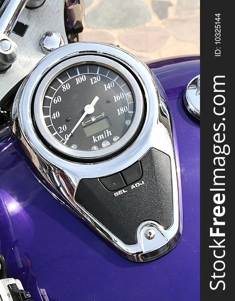 A speedometer of a blue motorcycle in close up. A speedometer of a blue motorcycle in close up