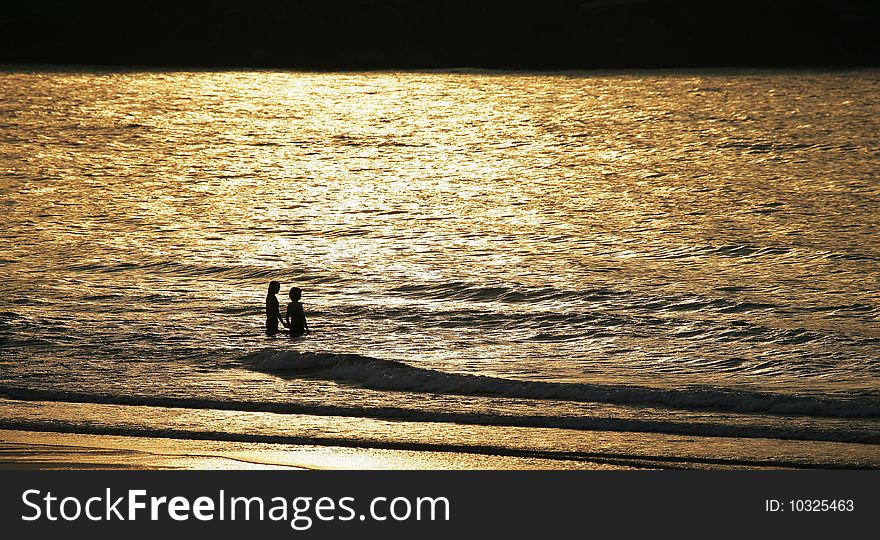 The lover plays with water under the setting sun, matches the golden yellow sea level to appear especially romantically. The lover plays with water under the setting sun, matches the golden yellow sea level to appear especially romantically