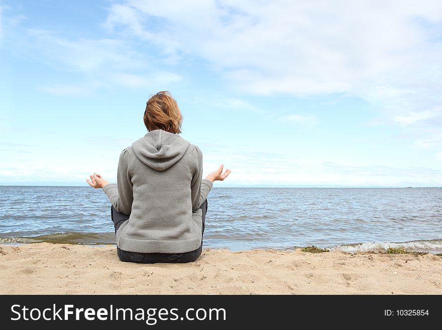 The woman meditates on seacoast. The woman meditates on seacoast