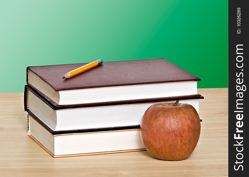 Apple And Pencil On Top Of Books
