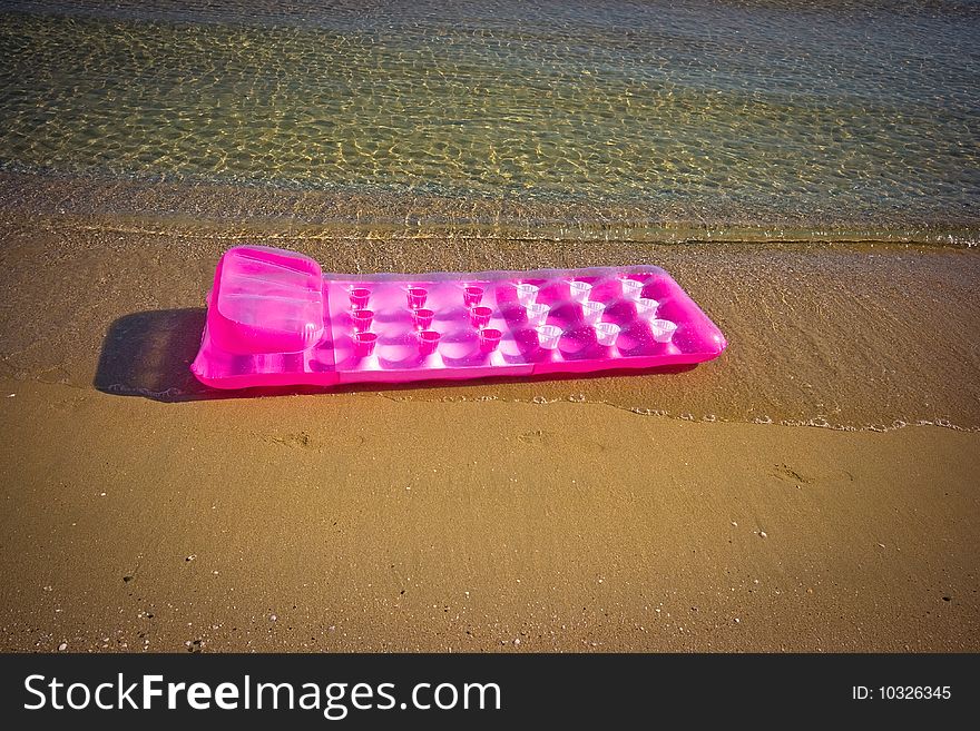 Pink inflatable raft on the sand sea beach