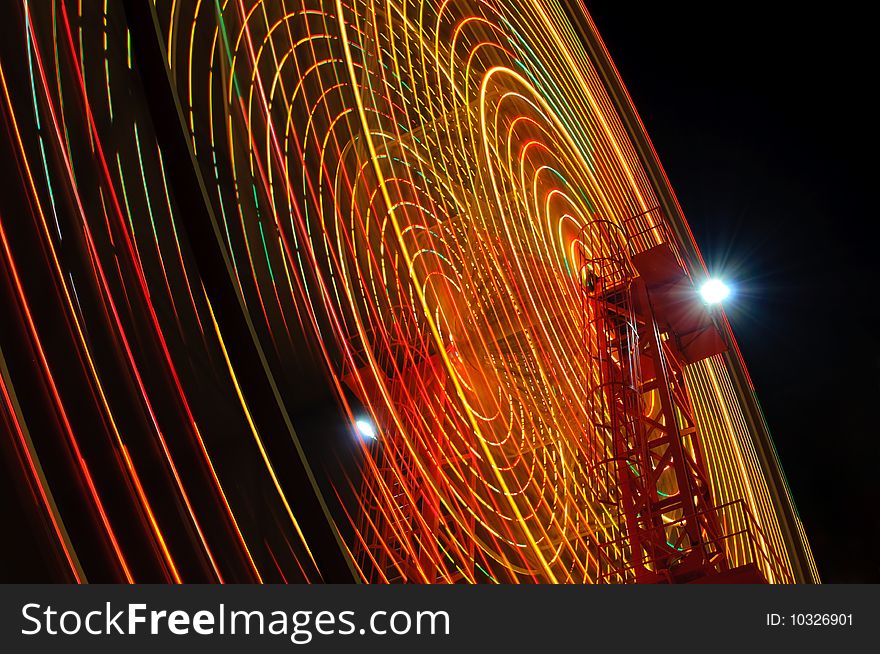 A Ferris Wheel spins at night. A Ferris Wheel spins at night
