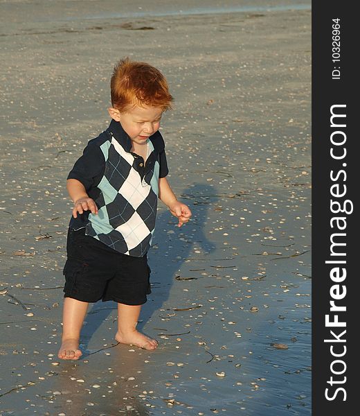 Photo of a boy toddler alone on the beach. Photo of a boy toddler alone on the beach