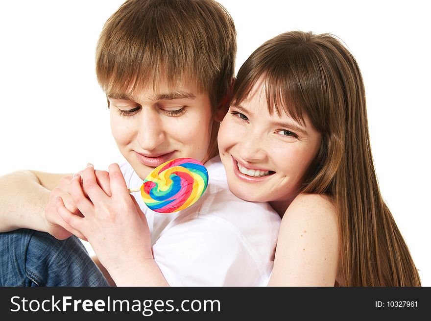 A young teenage couple shares a lollipop